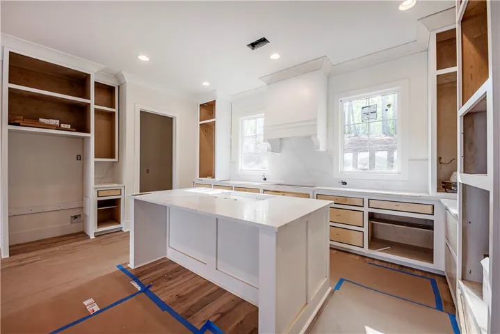 This spacious kitchen offers a large island, generous cabinetry, and ample natural light, ideal for culinary endeavors.