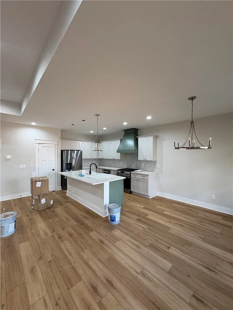 This spacious kitchen and living area features warm wood flooring and elegant​​‌​​​​‌​​‌‌​‌‌​​​‌‌​‌​‌​‌​​​‌​​ fixtures.