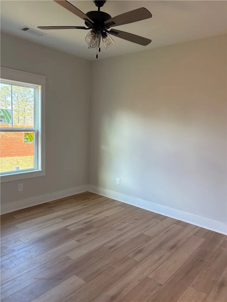 This bright room features durable flooring and a ceiling fan, offering comfortable living.