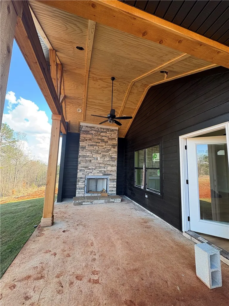 Enjoy outdoor living with this expansive patio, featuring an inviting stone fireplace for cozy evenings.