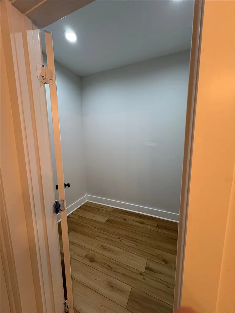 This spacious closet offers ample storage and features beautiful wood flooring.