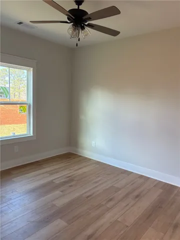 This bright room features durable flooring and a ceiling fan, offering comfortable living.