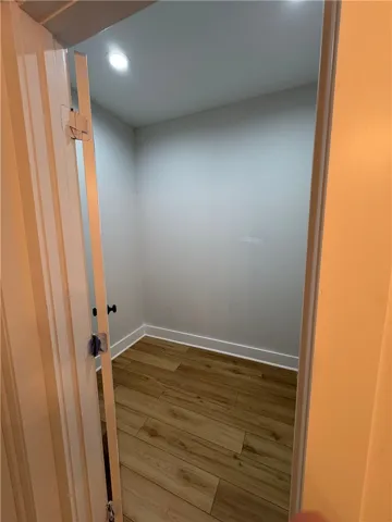 This spacious closet offers ample storage and features beautiful wood flooring.