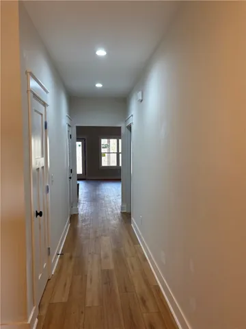 This interior hallway features sleek flooring and recessed lighting, offering a seamless flow throughout the home.