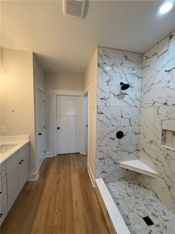 This newly renovated bathroom features a spacious shower and elegant vanity.