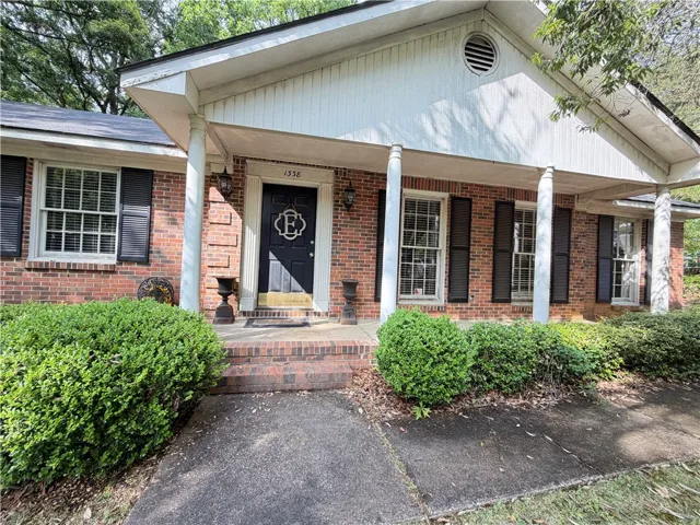 This classic brick residence features an inviting front porch, offering a warm welcome.
