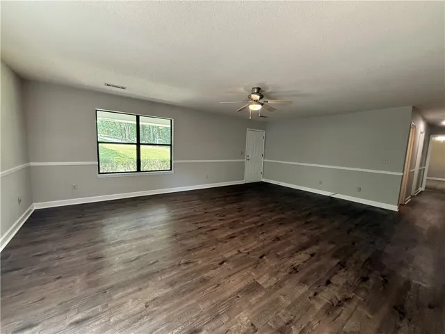 This inviting living area boasts rich hardwood flooring and ample natural light, perfect for everyday living.