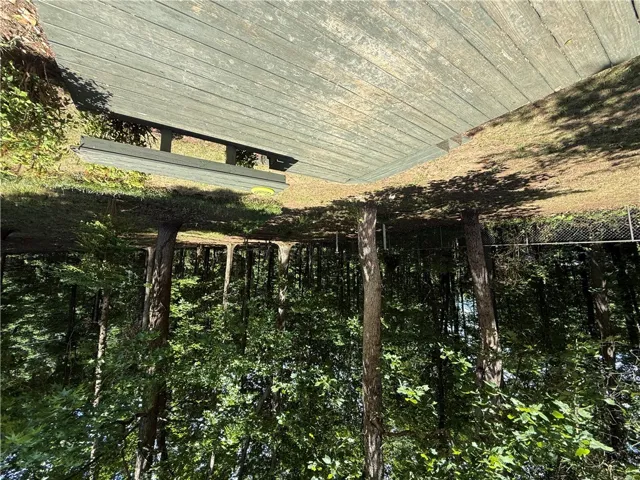 This elevated outdoor space provides a serene vantage point overlooking a lush, wooded landscape.