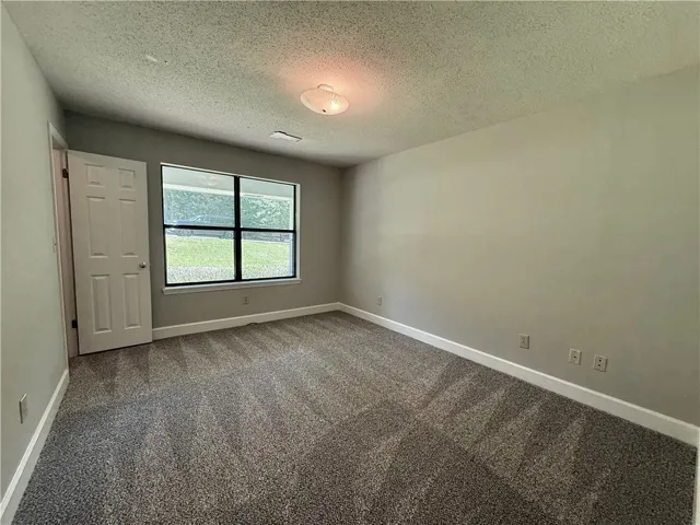 This cozy bedroom features a neutral palette and ample natural light, creating a serene personal retreat.