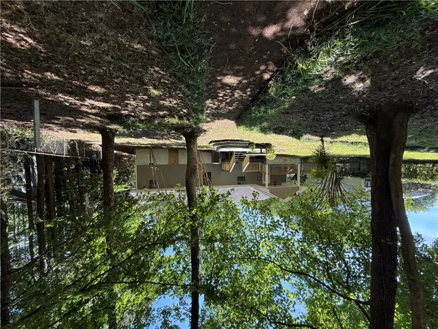 This spacious yard features mature trees and a charming home with a multi-level deck.