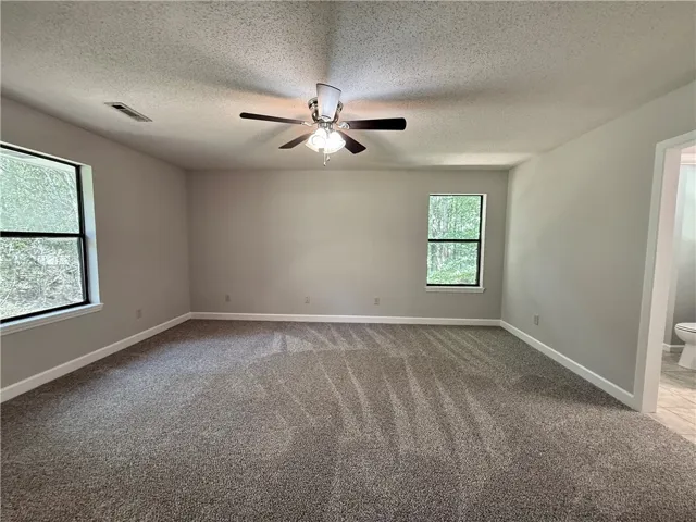 The primary bedroom offers ample natural light and a comfortable atmosphere for relaxation.