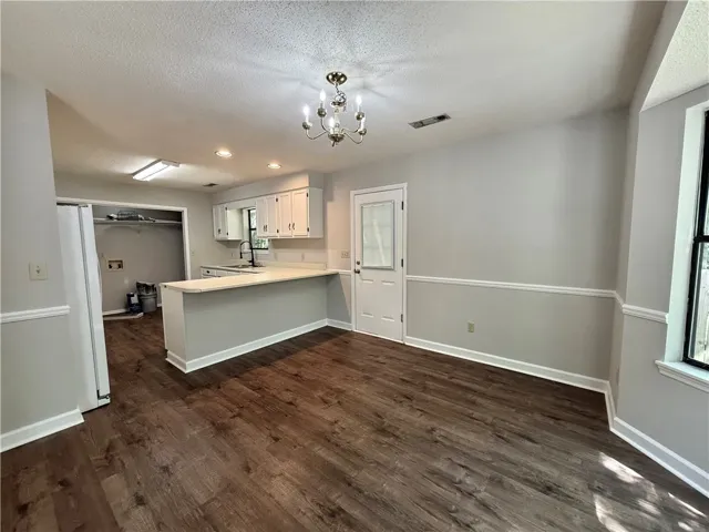 Bright and inviting kitchen and dining area featuring rich flooring and modern fixtures.