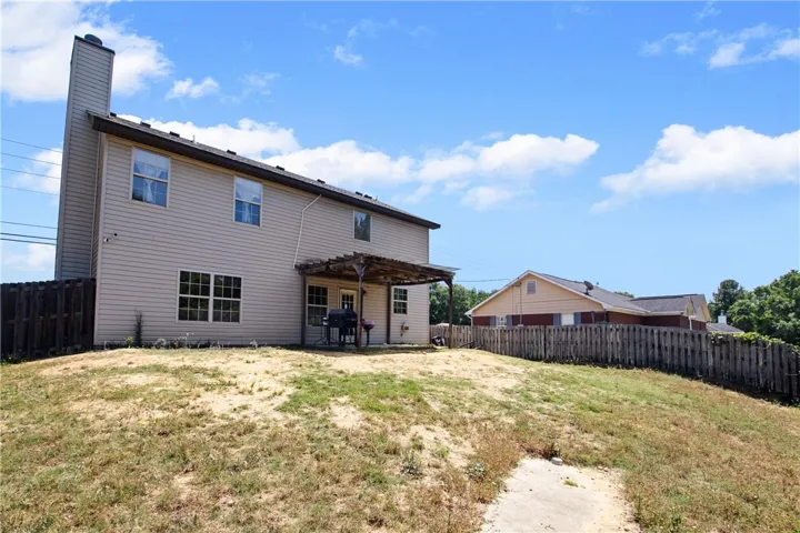 This spacious backyard features a pergola-covered patio, perfect for outdoor living and entertaining.
