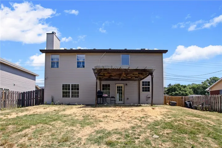This two-story residence features a backyard with a pergola, perfect for outdoor enjoyment.