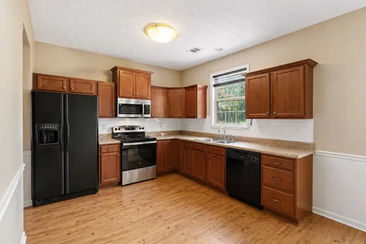 This spacious kitchen offers ample cabinet storage and all the essential appliances.