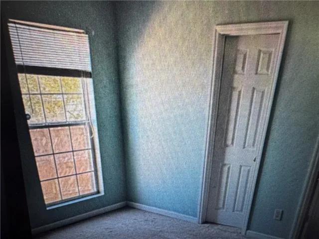 This cozy bedroom features soft carpet and a window for natural light.