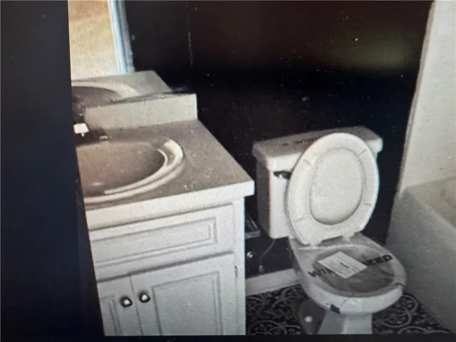 This bathroom features a sleek vanity and commode, providing essential amenities for comfortable living.