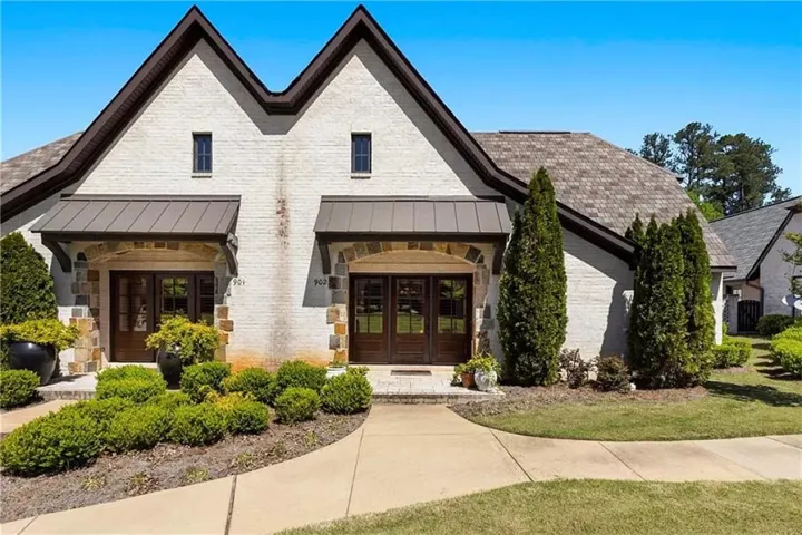 This charming home showcases a unique architectural design with elegant stone accents and well-maintained landscaping.