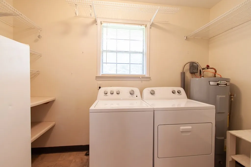 This functional laundry room offers a washer and dryer that convey and ample storage for organization.