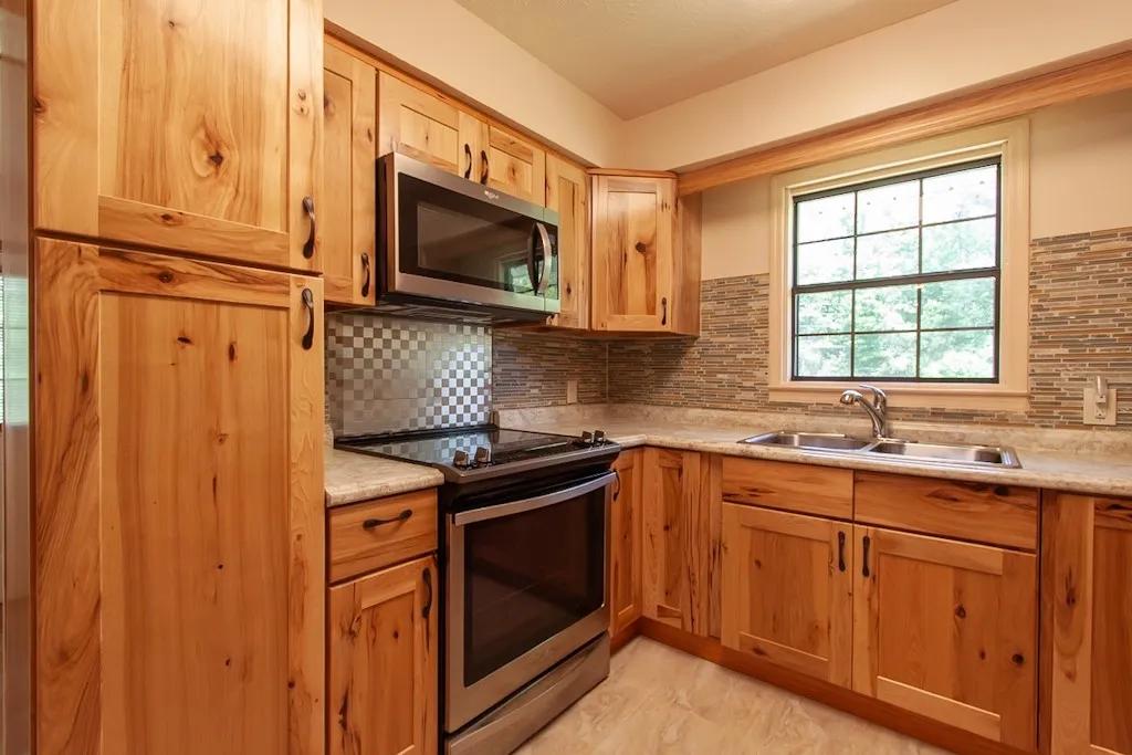 Kitchen with electric range and pantry cabinet.