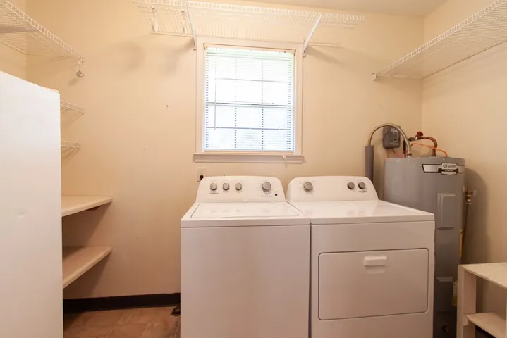 This functional laundry room offers a washer and dryer that convey and ample storage for organization.