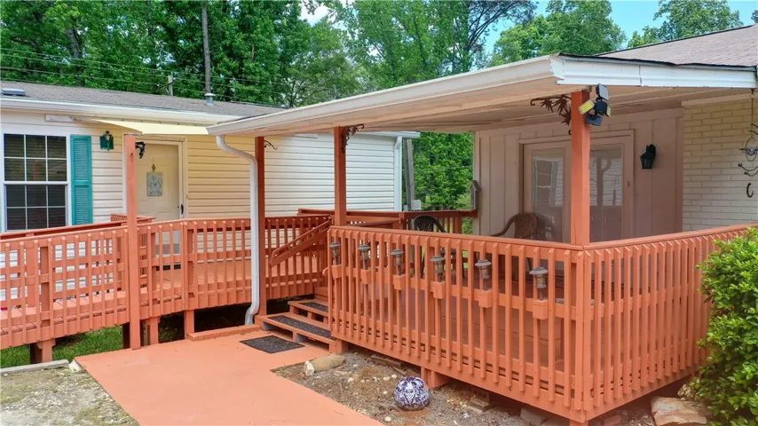 The covered deck has an attached ramp for easy access to the mobile home.