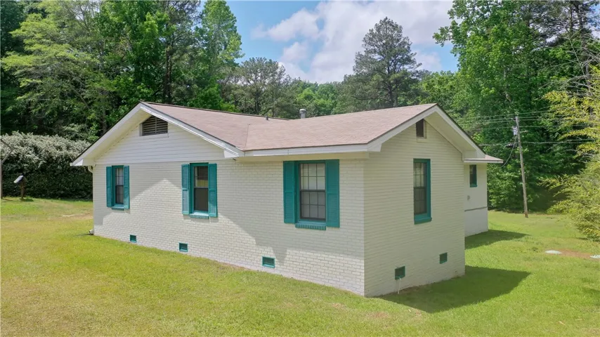 This charming home offers a serene escape, nestled among lush greenery and an expansive yard.