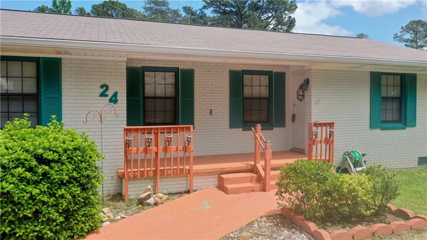This charming home offers a welcoming facade with classic details and lush landscaping.