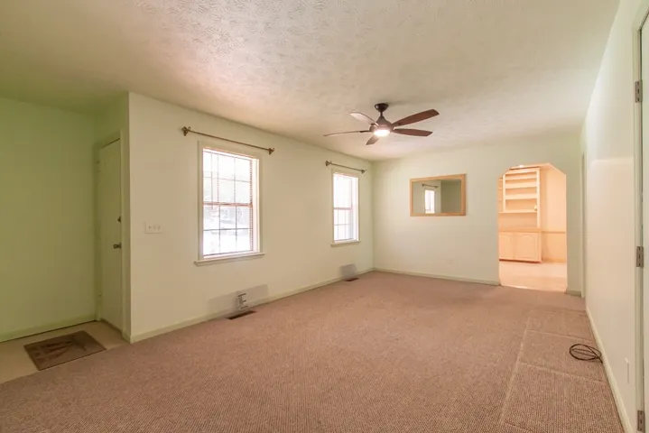 This inviting living area features warm neutral tones and ample natural light, creating a comfortable ambiance.