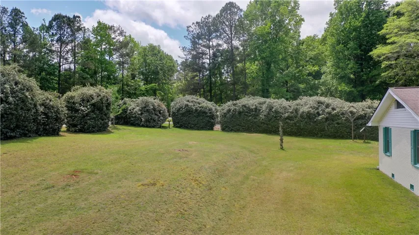 Side View with expansive green lawn surrounding the home, offering abundant space for outdoor enjoyment.