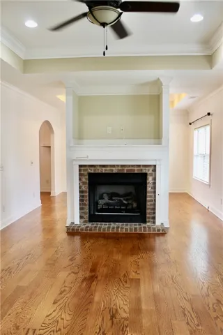 This living area features a classic brick fireplace and elegant hardwood flooring, perfect for cozy gatherings.