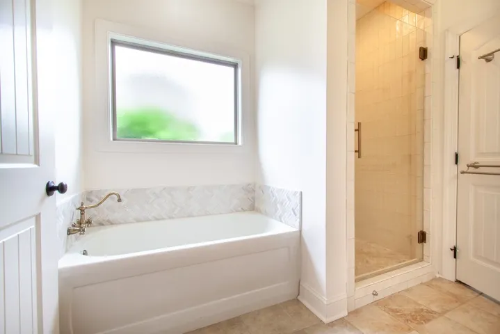This bathroom features a deep soaking tub and a spacious walk-in shower for ultimate comfort.