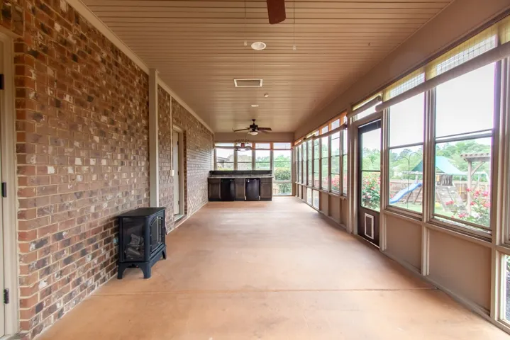 This inviting porch, featuring a durable concrete floor, offers ample space for outdoor living.