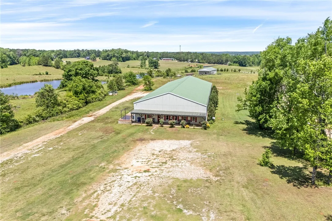 This aerial view showcases a serene rural landscape with a spacious barn.