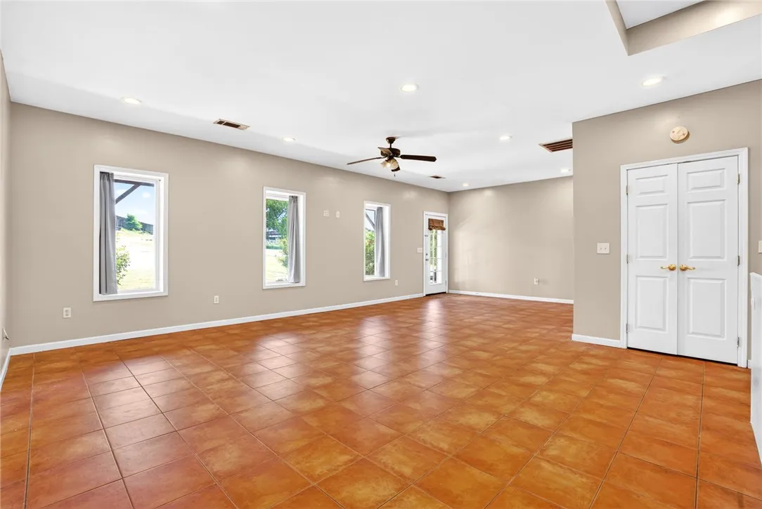 This expansive space features large windows and durable tile flooring, perfect for versatile living.