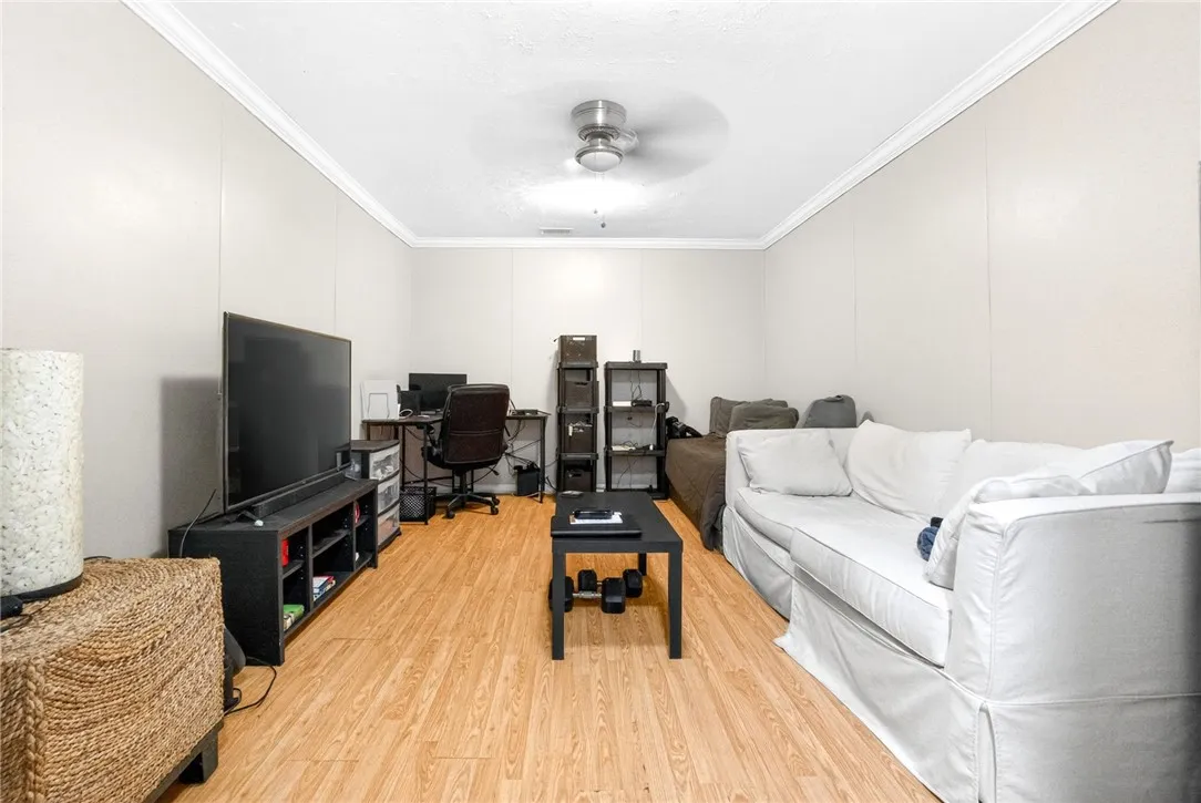 This versatile living area features durable flooring and a refreshing ceiling fan.