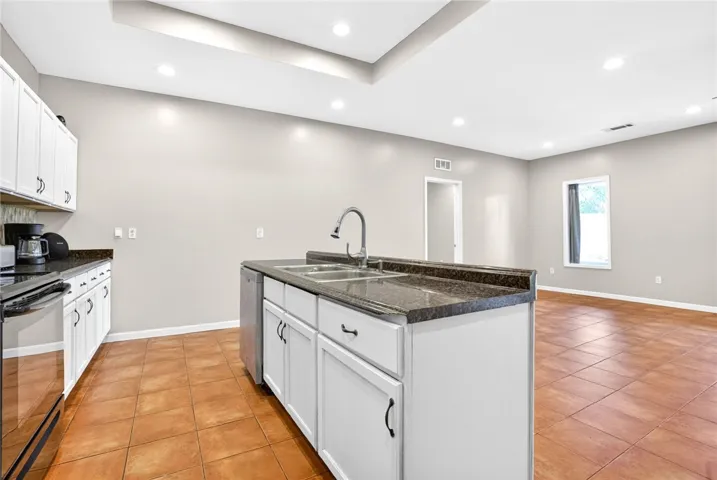 This spacious kitchen offers a functional island with ample counter space and modern appliances.