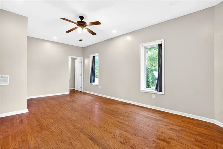 This spacious room features rich hardwood flooring and abundant natural light.