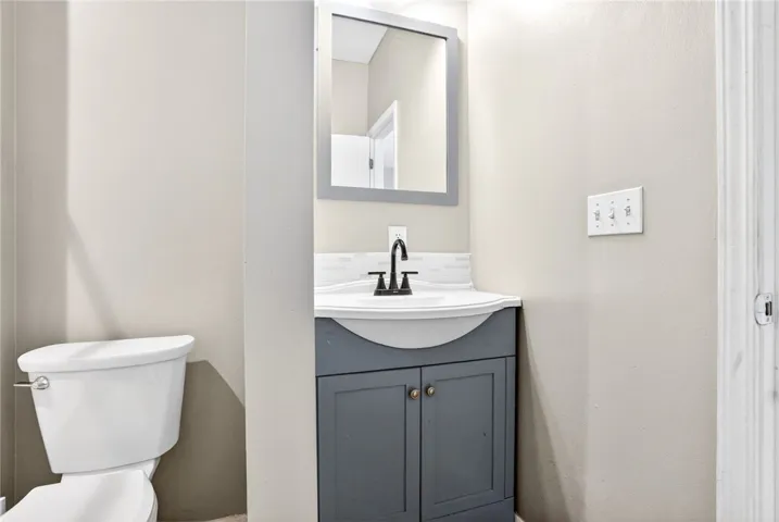 This powder room features a modern vanity and essential amenities for convenience.