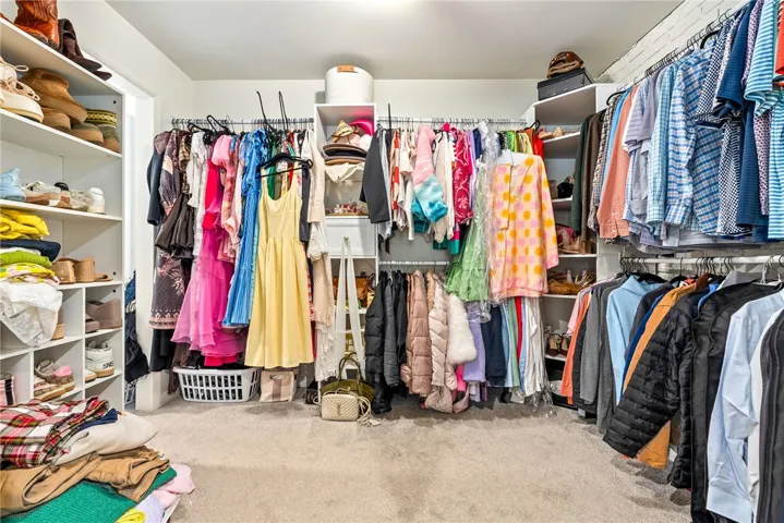 This spacious walk-in closet features ample storage with shelving and hanging rods.