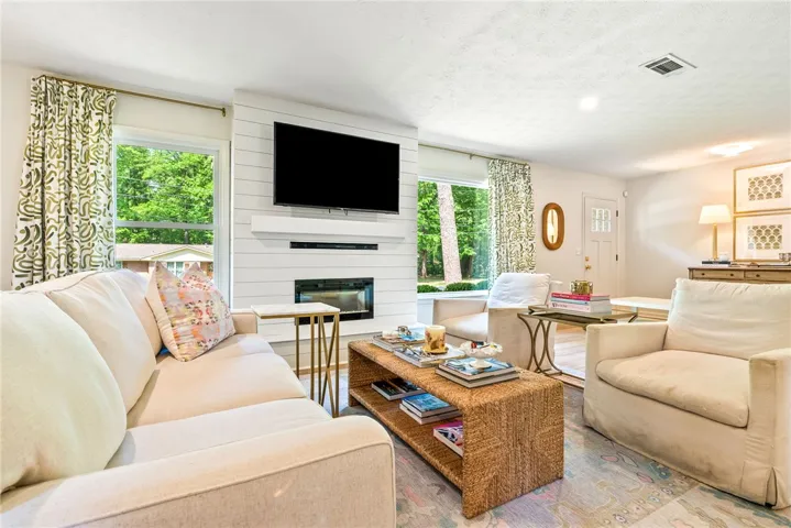 This bright living space showcases a beautiful fireplace and ample natural light.