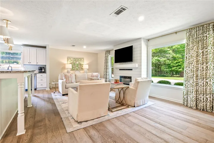 This inviting space offers an open layout, hardwood floors, and a charming fireplace.