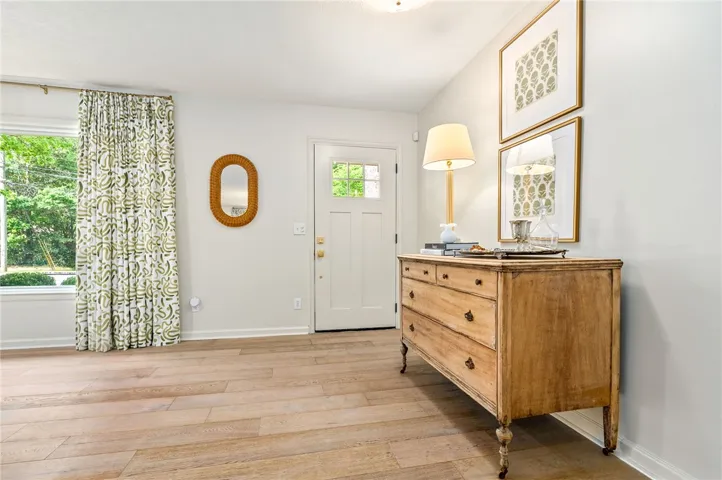 This bright and inviting entry features a charming doorway, large window, and durable flooring.