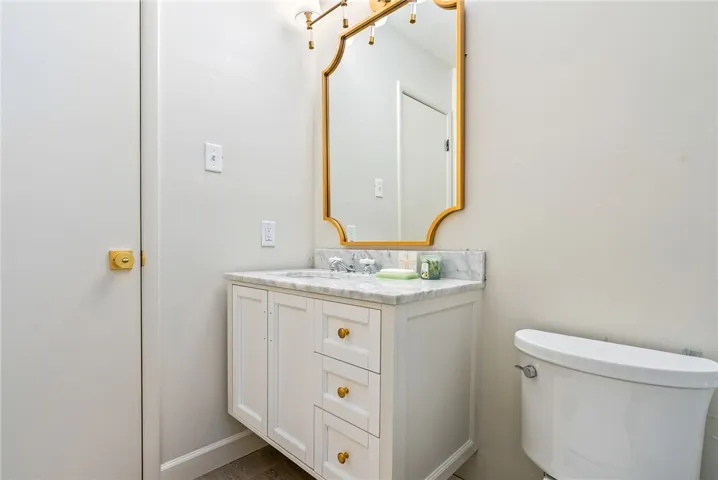 This bathroom features a sleek vanity with a classic mirror and elegant fixtures.