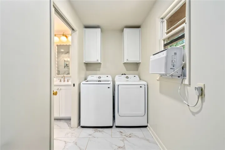 This laundry area features modern appliances and elegant flooring, creating a functional and attractive space.