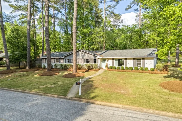 This charming residence is nestled among mature trees, offering a serene and private living experience.