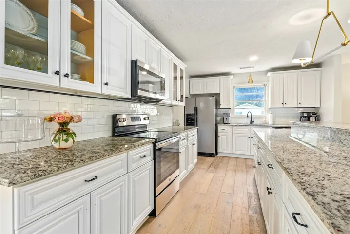 This kitchen features sleek countertops, pristine cabinetry, and modern appliances for an inviting culinary space.
