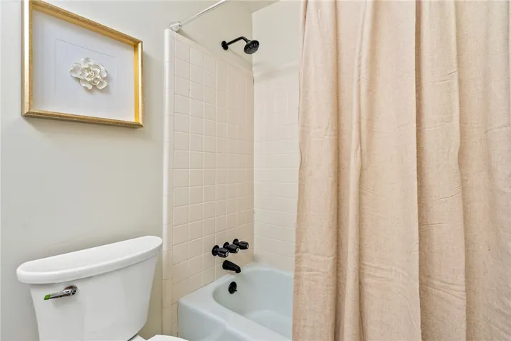 This bathroom features classic tile work and a functional tub and shower combination.