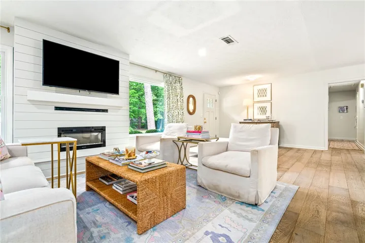 This bright living space features a modern fireplace and elegant hardwood flooring, perfect for comfortable living.