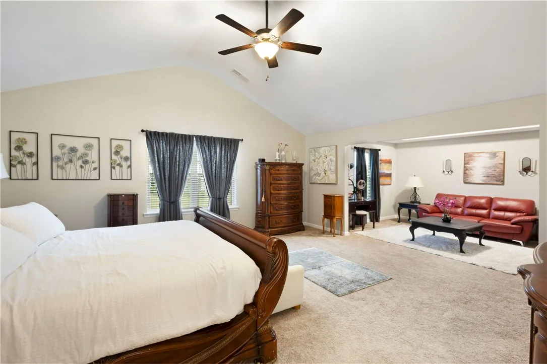 This spacious primary bedroom features vaulted ceilings and ample room for both rest and relaxation.